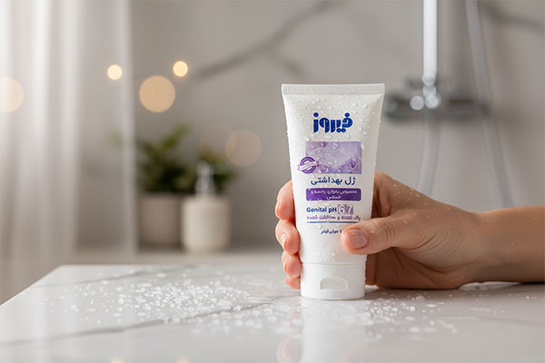 ژل بهداشتی بانوان یائسه فیروز در دست با پس‌زمینه حمام