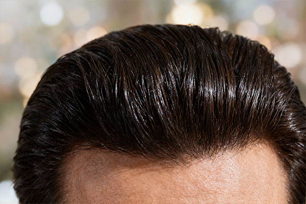 نمای نزدیک از لوسیون تقویت کننده مو دئودراگ با موهای سالم