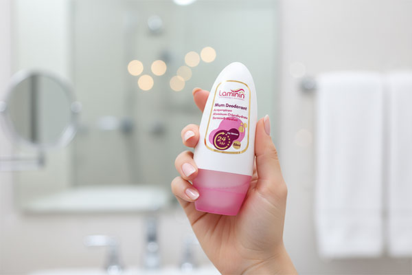 دست بانو در حال استفاده از رول دئودرانت بانوان لامینین