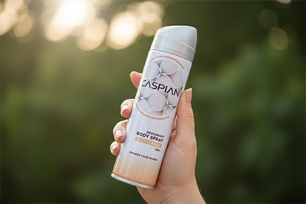 اسپری آئورا کاسپین در دست بانو با زمینه طبیعی