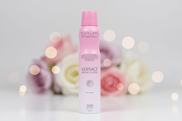 نمای نزدیک اسپری ورساچه برایت کریستال بادی کر با پس‌زمینه گل‌دار