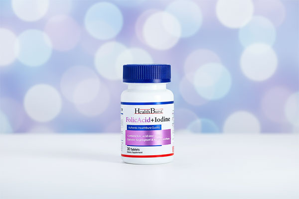 قرص فولیک اسید پلاس ید هلث برست روی سطح سفید