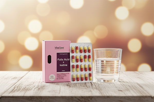 کپسول فولیک اسید و ید ویواتیون کنار لیوان آب