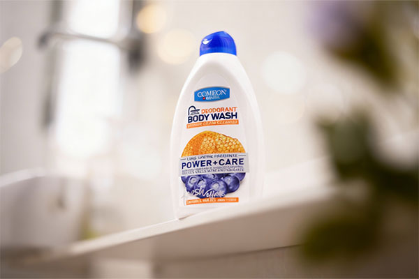 شامپو بدن کرمی عسل و بلوبری کامان روی قفسه حمام