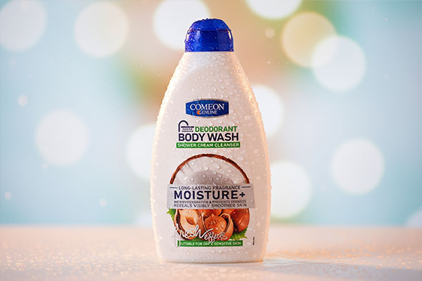 نمای نزدیک شامپو بدن پوست خشک کامان با قطرات آب