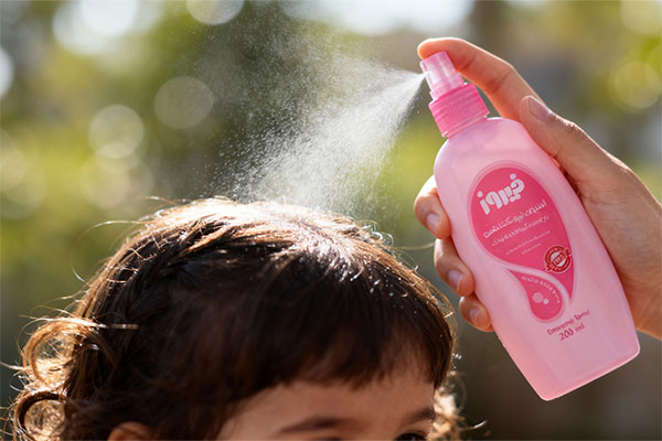 اسپری گره باز کن فیروز صورتی در حال استفاده روی موی کودک