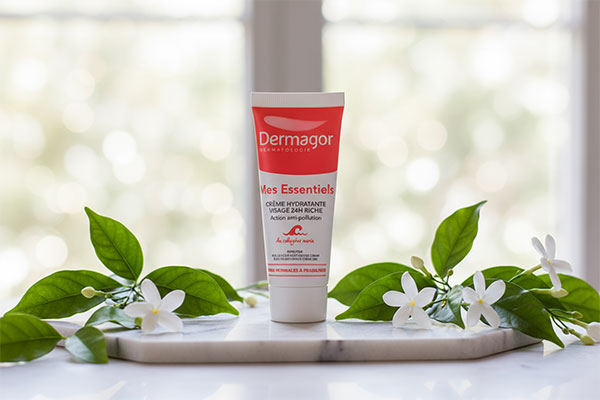 تیوپ کرم مرطوب کننده اسنشیال درماگور روی سطح مرمر سفید