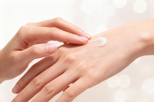 کرم مرطوب‌کننده دست وچه در حال استفاده روی پوست دست
