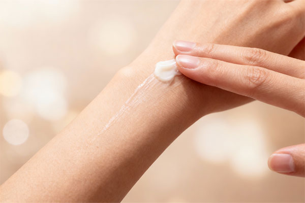 دست در حال استفاده از کرم مرطوب کننده شیر و عسل دیپ سنس