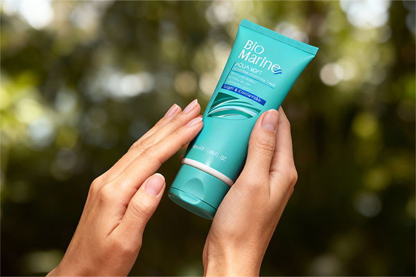 دست‌ها در حال استفاده از کرم رطوبت رسان دست و ناخن بایومارین