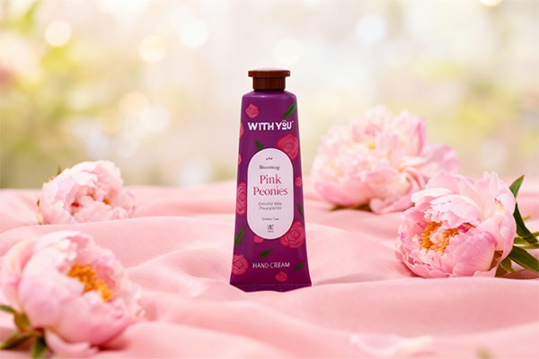 کرم مرطوب کننده دست گل پیونی ویت یو روی پارچه صورتی با گلهای پیونی