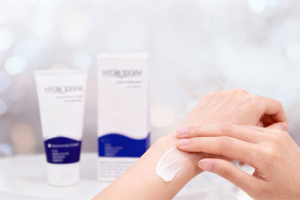 دست در حال استفاده از کرم مرطوب کننده هیدرودرم برای آبرسانی پوست