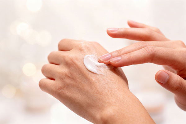 دست در حال استفاده از کرم دست هانی شی نئودرم برای رطوبت‌رسانی