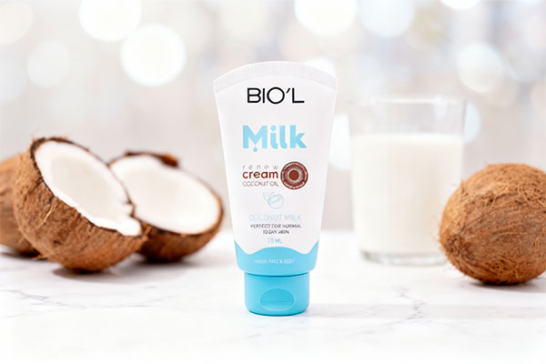 کرم مرطوب کننده شیر و نارگیل بیول روی سطح مرمری با نارگیل و شیر