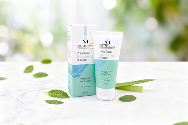 کرم مرطوب کننده پوست چرب مدیلن روی سطح مرمری با برگ‌های سبز