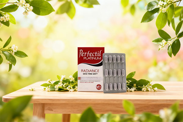 قرص پرفکتیل پلاتینوم ویتابیوتیکس در کنار برگ‌های سبز و گل‌ها