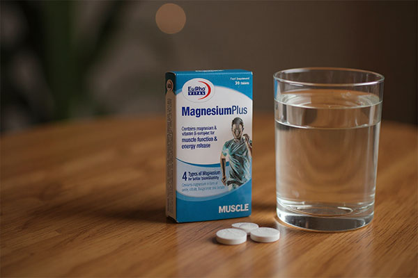 تصویر قرص منیزیم پلاس یوروویتال کنار لیوان آب