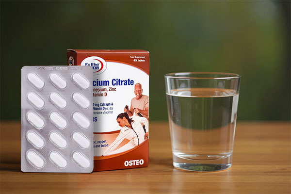 قرص کلسیم سیترات یوروویتال کنار لیوان آب