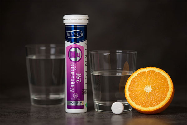 عکس منیزیم اکساید در کنار لیوان قرص جوشان و پرتقال