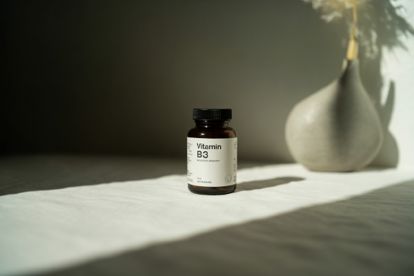 تصویر بطری مکمل ویتامین B3 با کیفیت بالا روی سطح سفید
